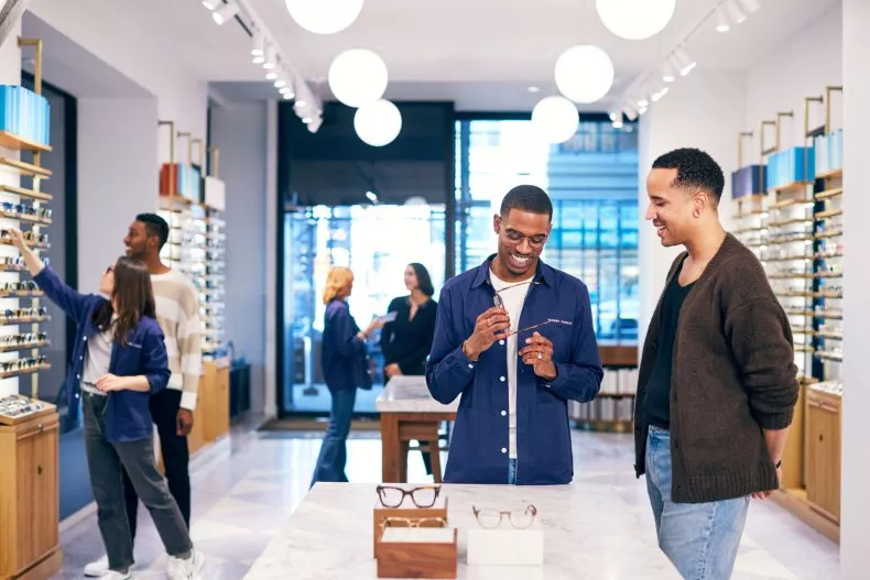 Warby Parker employees help customers browse frames in a store. The company achieved an overall score of 92.15 on the America's Best Retailers 2024 ranking.Warby Parker